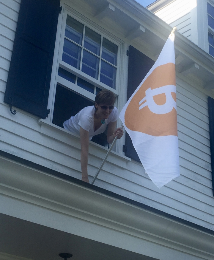 woman putting on a Bitcoin flag on her window