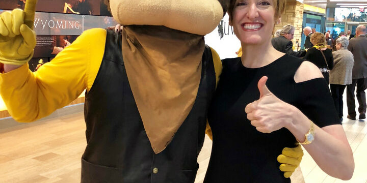 Caitlin taking a picture with a mascot